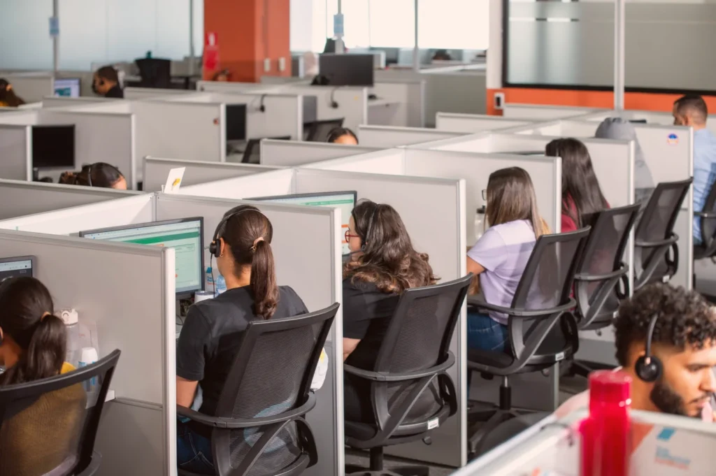 Rows of contact-center workstations with agents wearing headsets