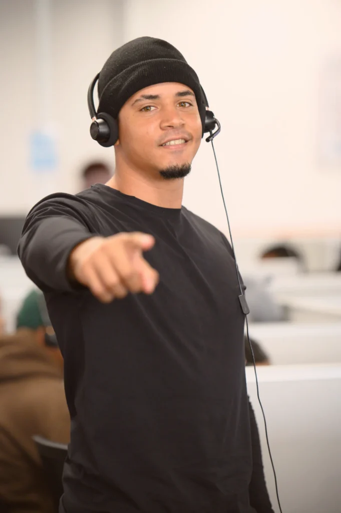 Man wearing a headset pointing toward the camera