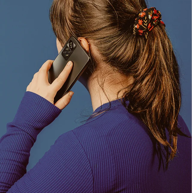 Woman holding a mobile phone to her ear, seen from behind
