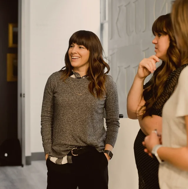 Two women talking in an office corridor