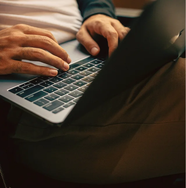 Close-up of hands typing on a laptop