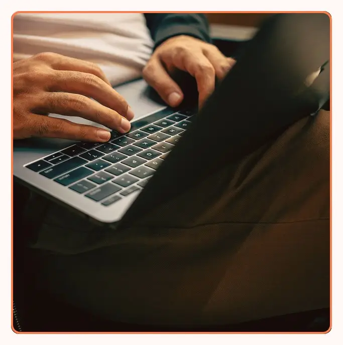 Close-up of hands typing on a laptop