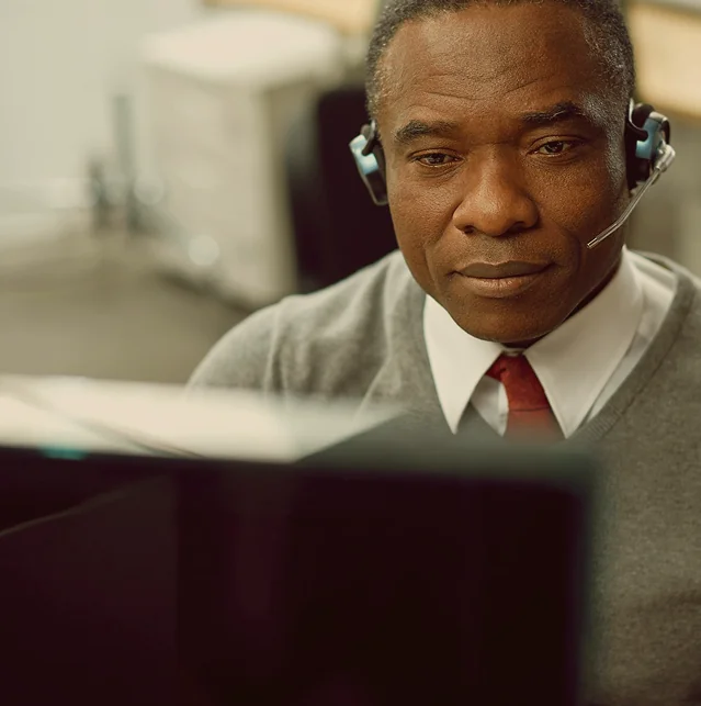 Man wearing a headset at a computer