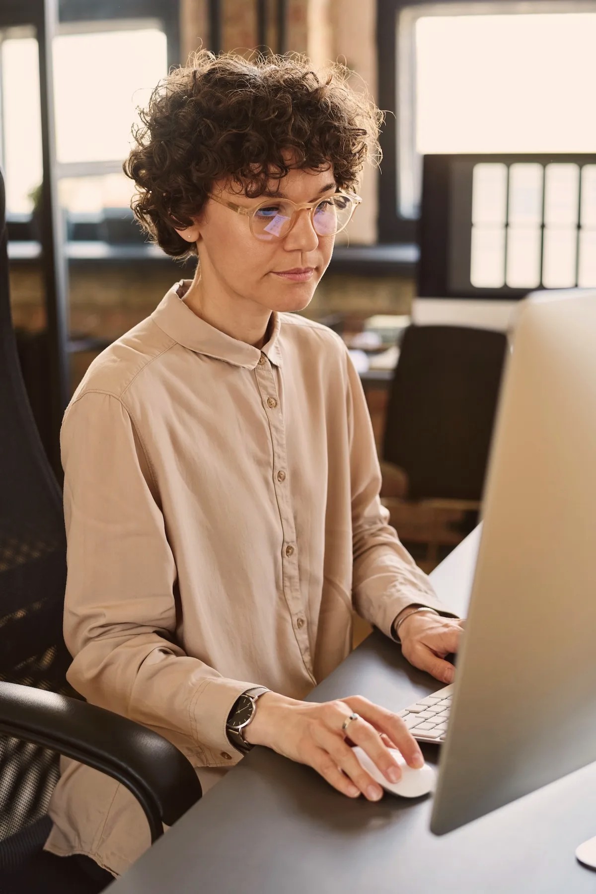 Woman with curly hair working at a computer