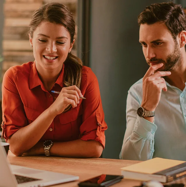A woman and a man in discussion at a desk