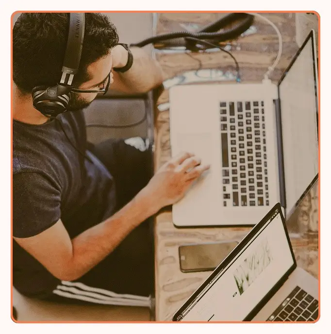 An agent in headphones handling chat and email at a laptop