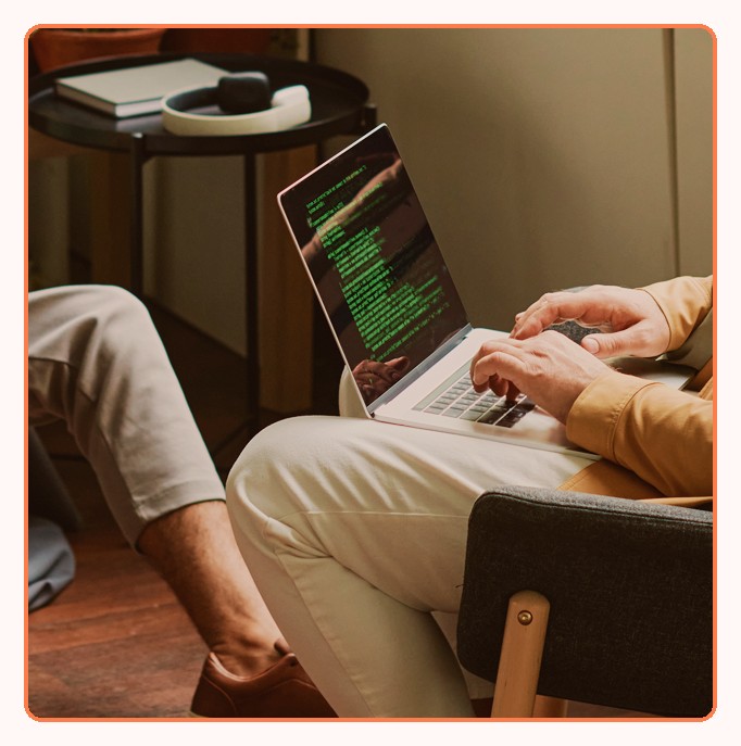 A developer working on a laptop with code on the screen