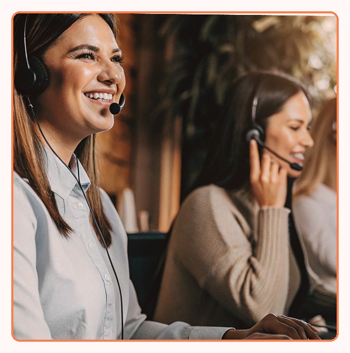 Two support agents in headsets smiling during calls