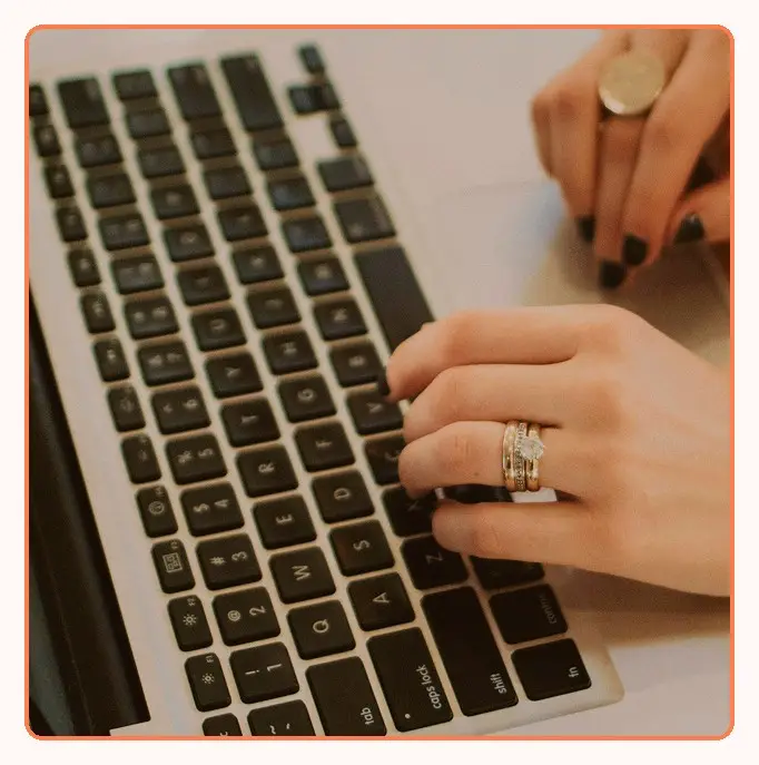 Close-up of hands typing on a laptop keyboard