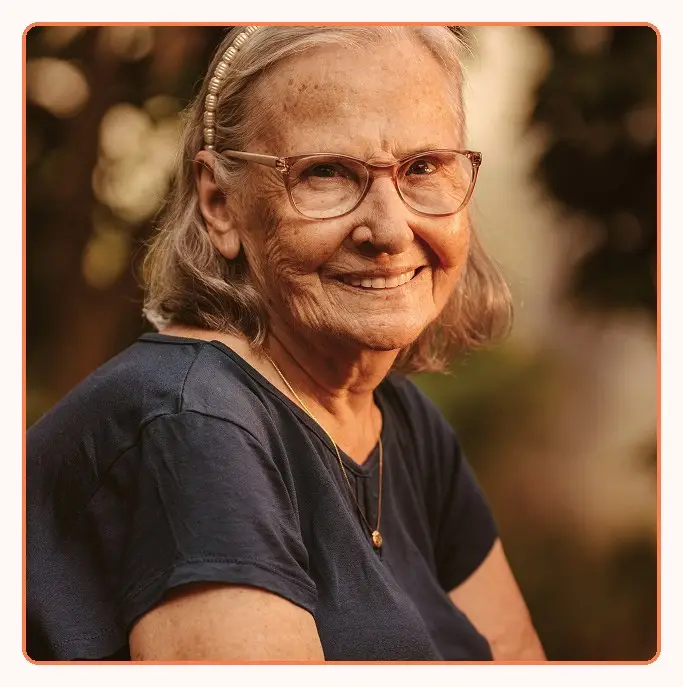 A smiling older woman in glasses