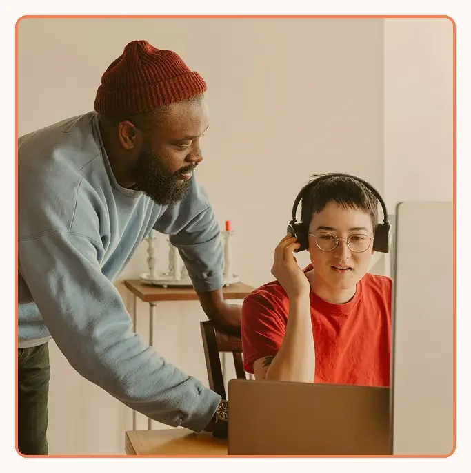 A supervisor coaching an agent at a workstation