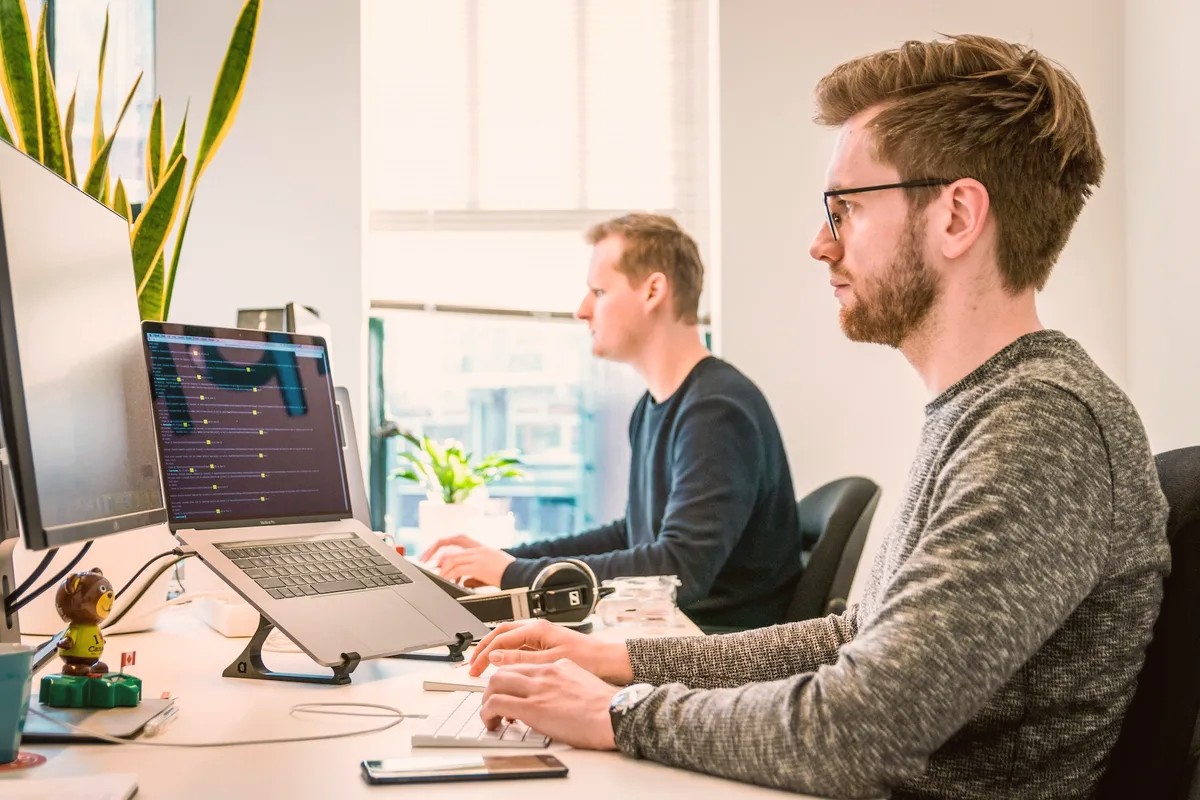 Two men working at computers in an open-plan office