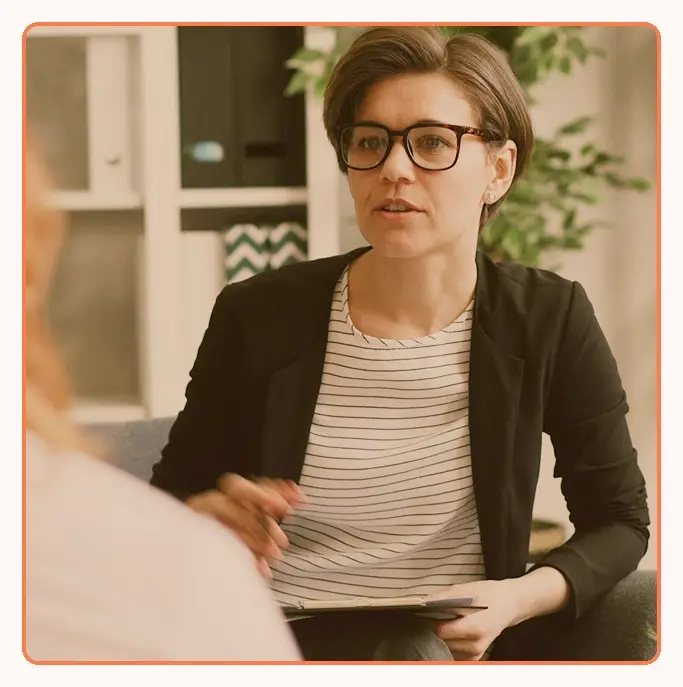 A consultant in glasses talking with a client during a meeting