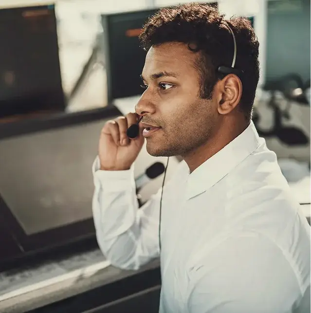 A support agent adjusting a headset mic during a call
