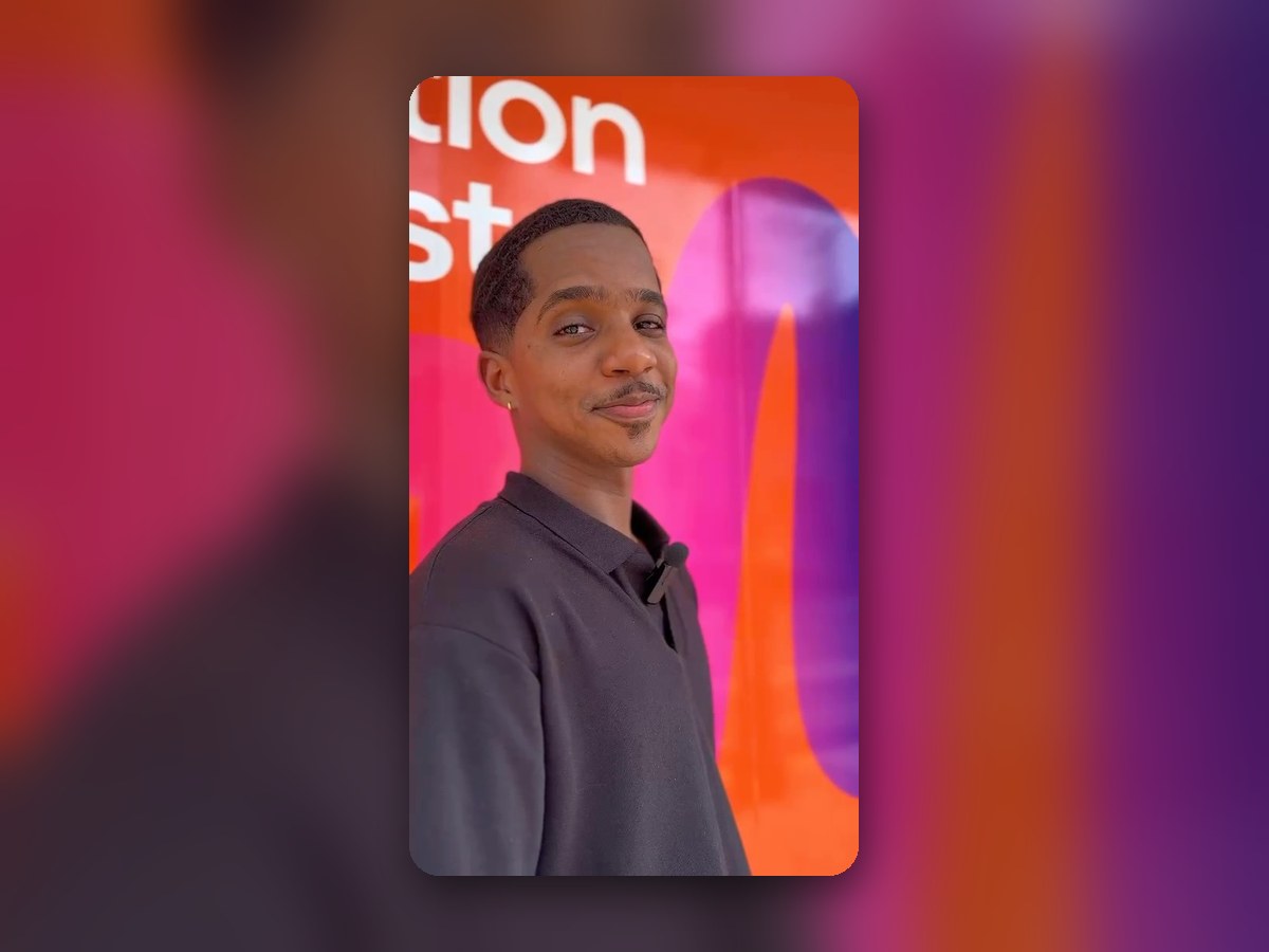 A VoiceTeam team member in front of the VoiceTeam brand wall, from the VoiceTeam TikTok